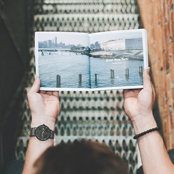 Man reading a travel guide book about new york