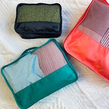 Lapoche packing cubes lying on a white bedspread