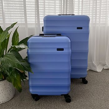 Periwinkle Luna Air 2 suitcases in a bedroom