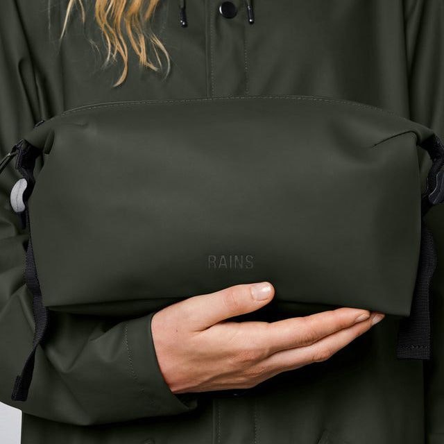 Woman holding a Rains Wash Bag in the colour green