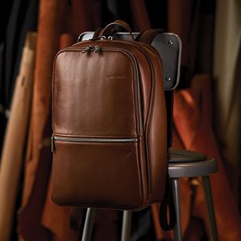 Samsonite Classic Leather Backpack in brown strapped over the back of a chair