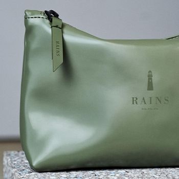 Rains Wash Bag in Olive on a marble counter