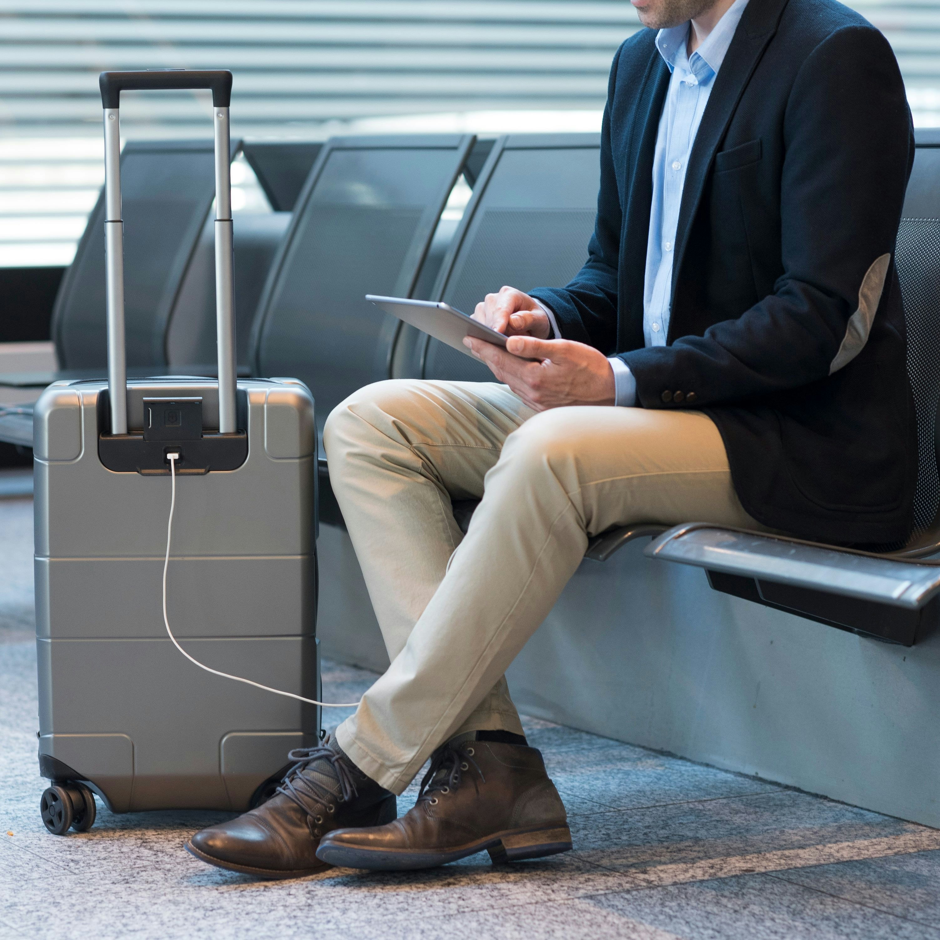 Businessman at airport with Victorinox luggage charging tablet