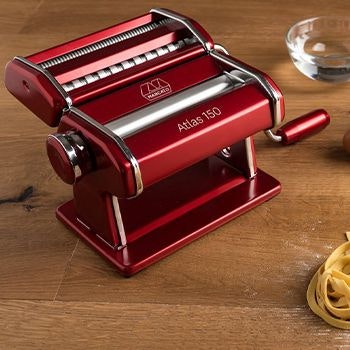 Red Pasta Machine with Pasta and bowl in background