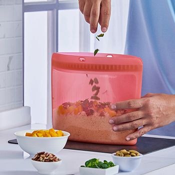 Ultimate silicone bag in red being filled with food