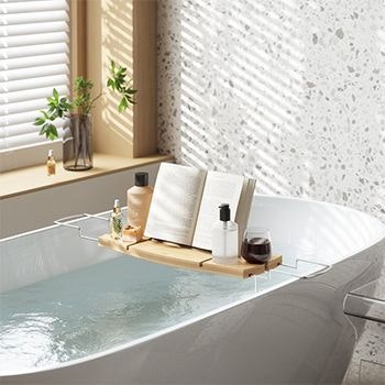 Umbra Aquala Bathtub caddy set up in the bath with a book, shower gel and wine on it
